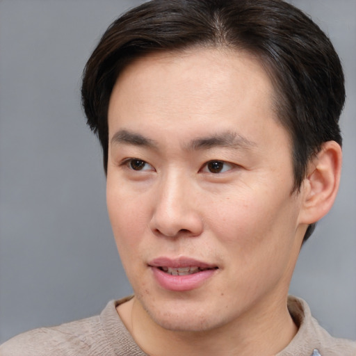 Joyful asian young-adult male with short  brown hair and brown eyes