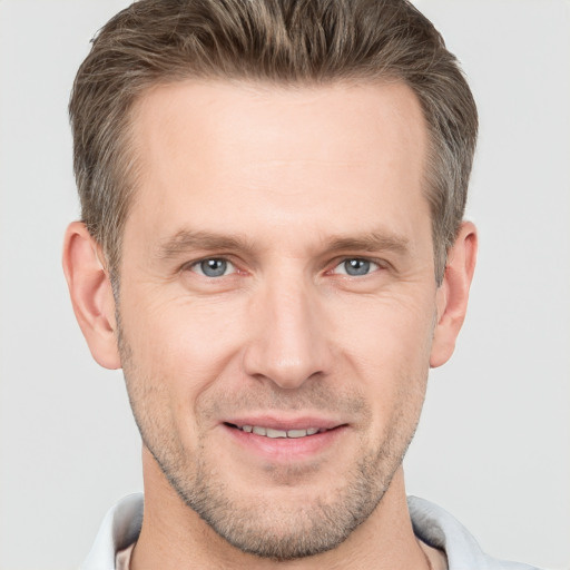 Joyful white adult male with short  brown hair and grey eyes