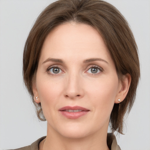 Joyful white young-adult female with medium  brown hair and grey eyes