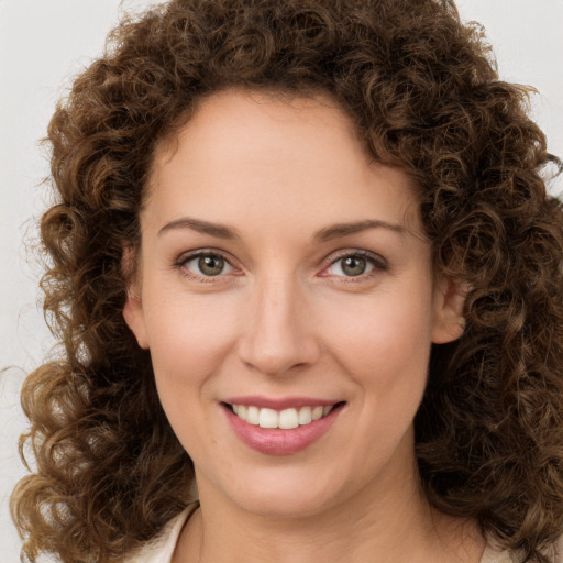 Joyful white young-adult female with medium  brown hair and green eyes