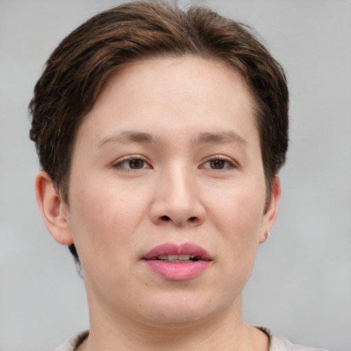 Joyful white young-adult female with short  brown hair and grey eyes