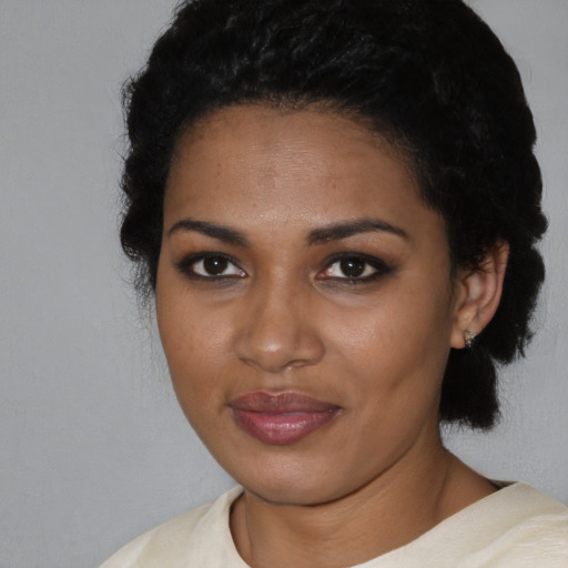 Joyful black young-adult female with short  black hair and brown eyes