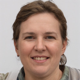 Joyful white adult female with medium  brown hair and grey eyes