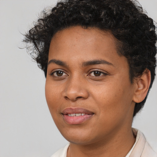 Joyful black young-adult female with short  brown hair and brown eyes