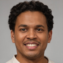 Joyful latino young-adult male with short  brown hair and brown eyes