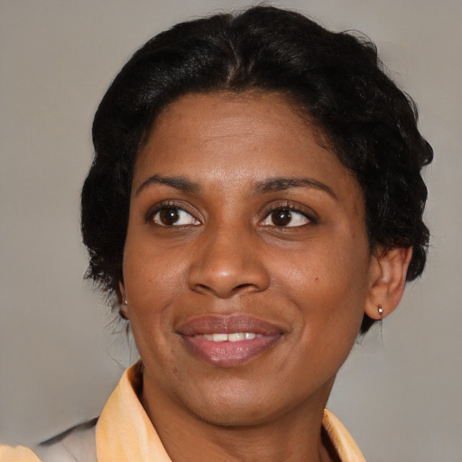 Joyful black adult female with medium  brown hair and brown eyes