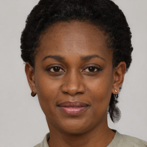 Joyful black young-adult female with short  black hair and brown eyes