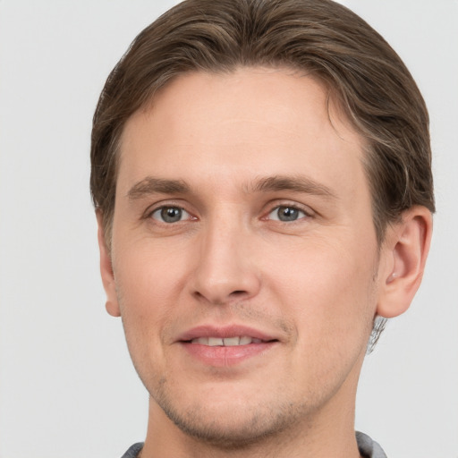 Joyful white young-adult male with short  brown hair and grey eyes