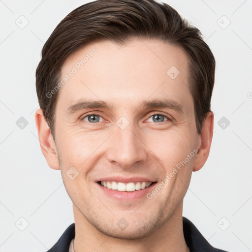 Joyful white young-adult male with short  brown hair and grey eyes