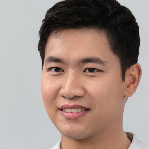 Joyful asian young-adult male with short  brown hair and brown eyes