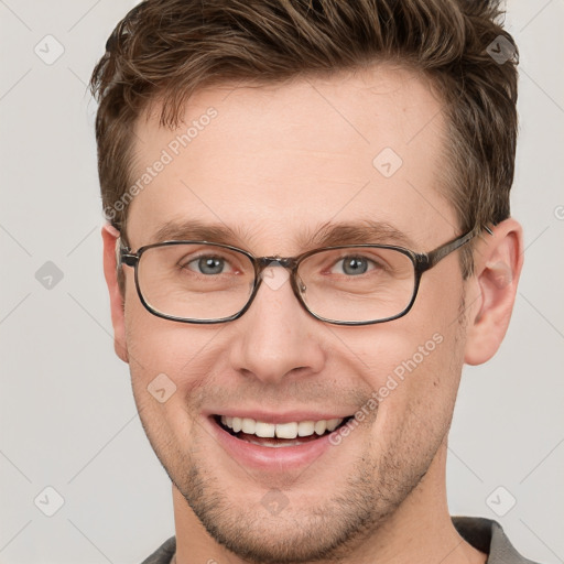 Joyful white young-adult male with short  brown hair and grey eyes