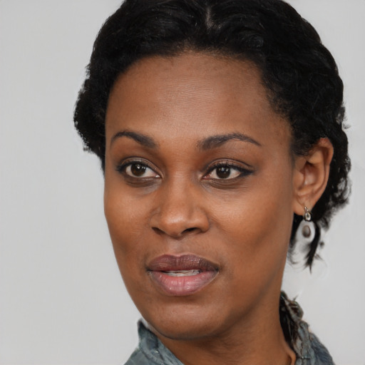 Joyful black adult female with short  black hair and brown eyes