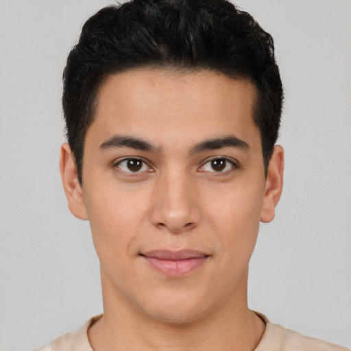 Joyful latino young-adult male with short  brown hair and brown eyes