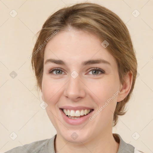 Joyful white young-adult female with medium  brown hair and grey eyes