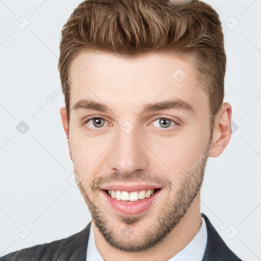 Joyful white young-adult male with short  brown hair and grey eyes