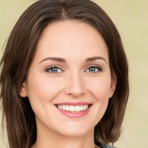 Joyful white young-adult female with long  brown hair and green eyes