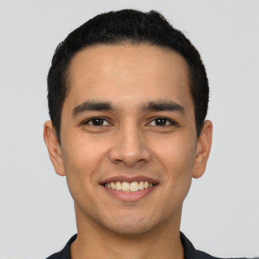 Joyful latino young-adult male with short  black hair and brown eyes