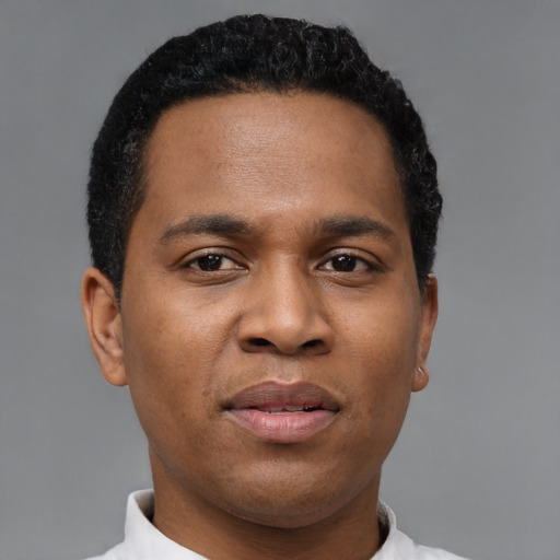 Joyful black young-adult male with short  black hair and brown eyes