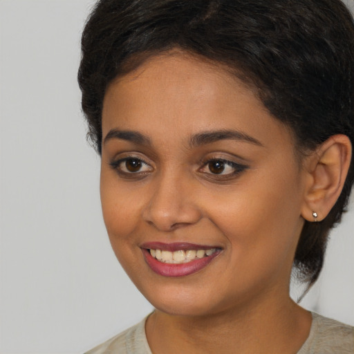 Joyful black young-adult female with medium  brown hair and brown eyes