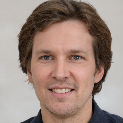 Joyful white adult male with short  brown hair and grey eyes