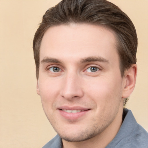 Joyful white young-adult male with short  brown hair and grey eyes