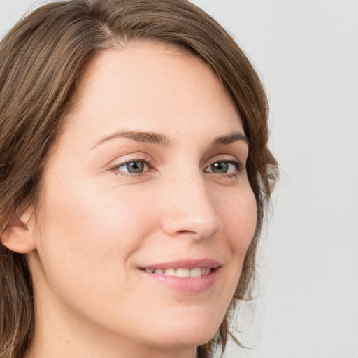 Joyful white young-adult female with long  brown hair and green eyes