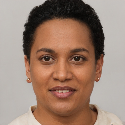 Joyful black young-adult female with short  brown hair and brown eyes