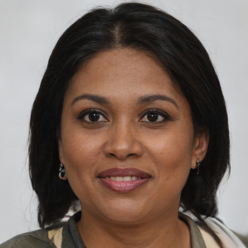 Joyful black adult female with medium  brown hair and brown eyes
