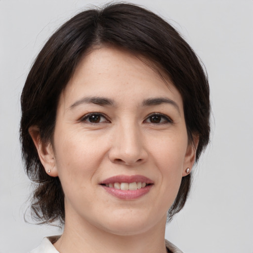 Joyful white young-adult female with medium  brown hair and brown eyes
