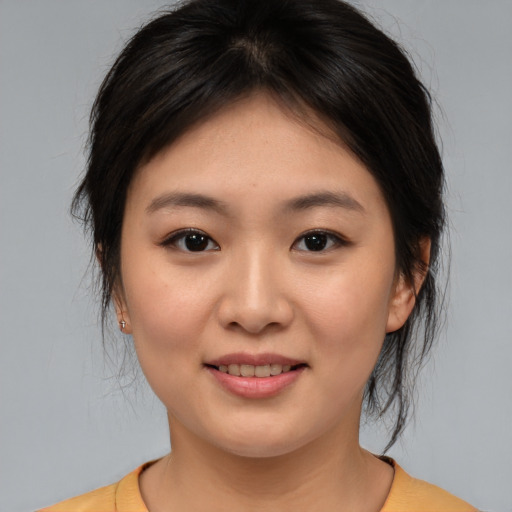 Joyful asian young-adult female with medium  brown hair and brown eyes