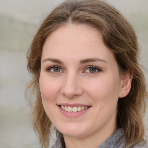 Joyful white young-adult female with medium  brown hair and grey eyes