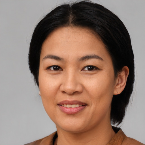 Joyful asian young-adult female with medium  brown hair and brown eyes