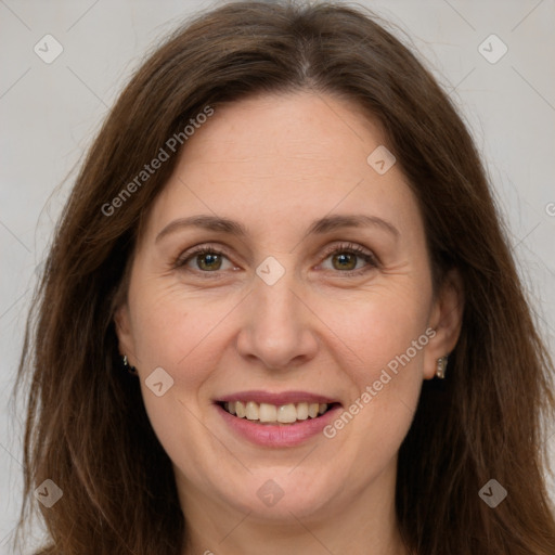 Joyful white adult female with long  brown hair and green eyes