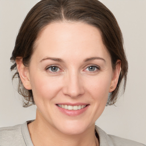 Joyful white young-adult female with medium  brown hair and grey eyes