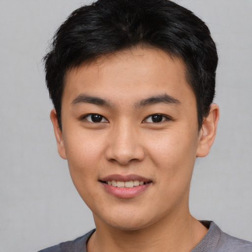 Joyful asian young-adult male with short  brown hair and brown eyes