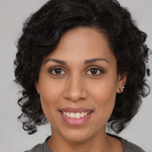 Joyful black young-adult female with medium  brown hair and brown eyes