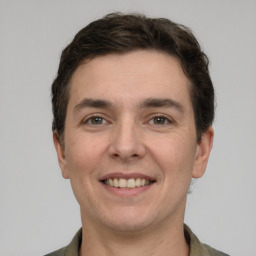 Joyful white adult male with short  brown hair and grey eyes