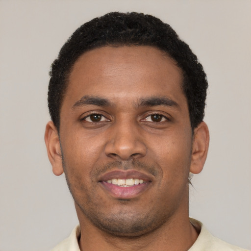Joyful black young-adult male with short  black hair and brown eyes