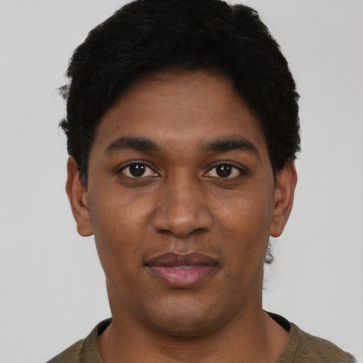 Joyful black young-adult male with short  black hair and brown eyes