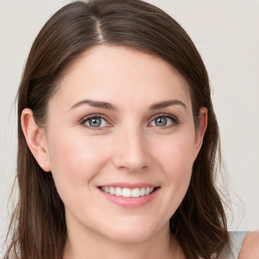 Joyful white young-adult female with long  brown hair and blue eyes