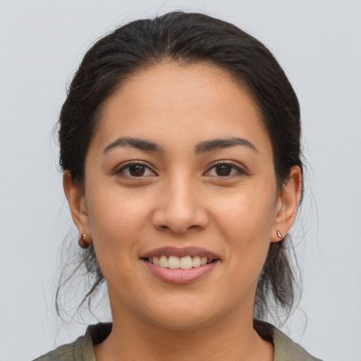 Joyful latino young-adult female with medium  brown hair and brown eyes