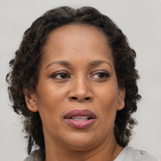 Joyful black adult female with medium  brown hair and brown eyes