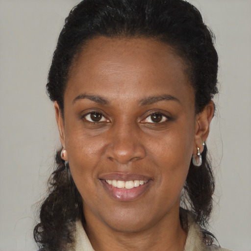 Joyful black adult female with medium  brown hair and brown eyes