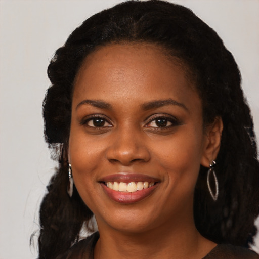 Joyful black young-adult female with long  black hair and brown eyes