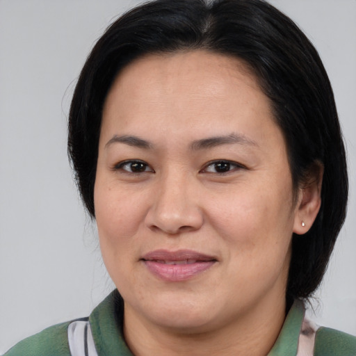 Joyful asian adult female with medium  brown hair and brown eyes