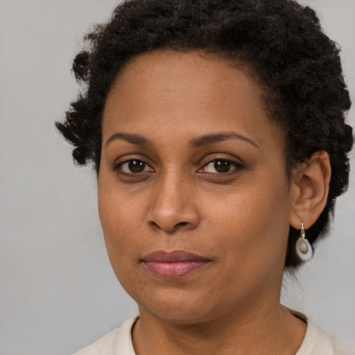 Joyful black young-adult female with short  brown hair and brown eyes