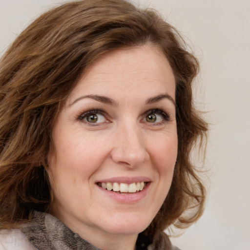 Joyful white young-adult female with medium  brown hair and green eyes