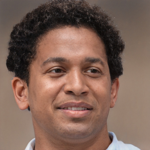 Joyful black adult male with short  brown hair and brown eyes