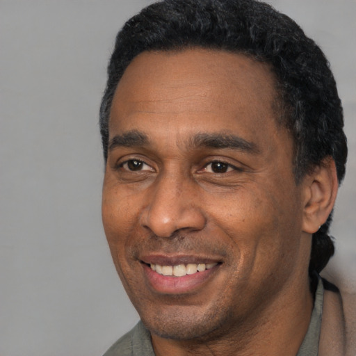 Joyful black adult male with short  black hair and brown eyes