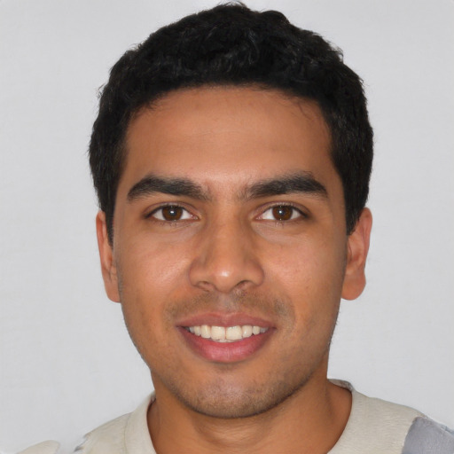 Joyful latino young-adult male with short  black hair and brown eyes